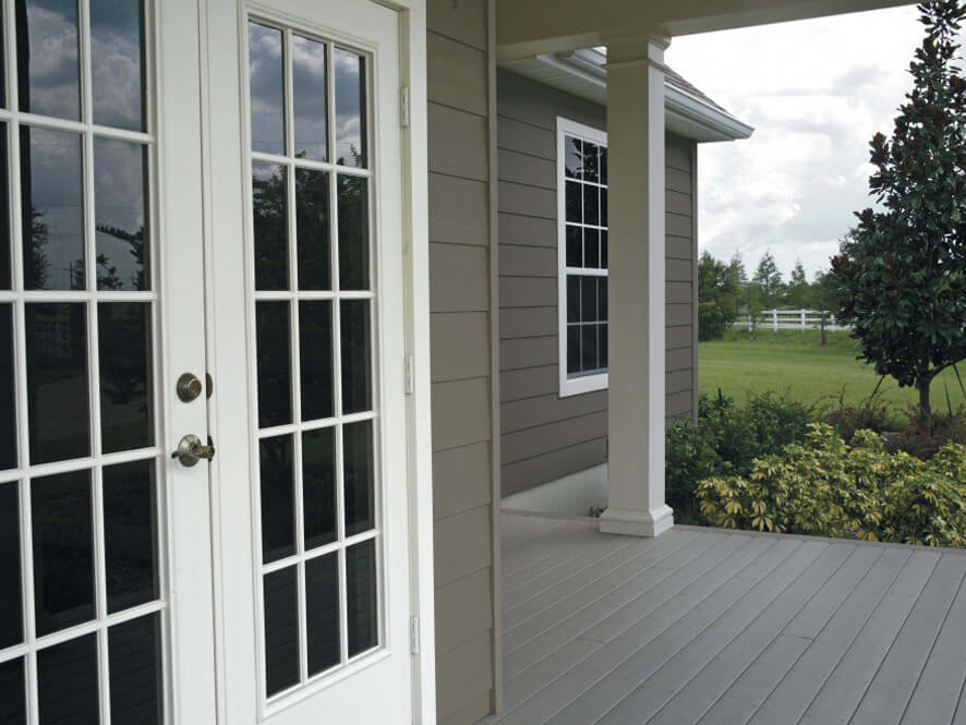 Brown Exterior Weatherboard with White Door Trims and Light Grey Support Beams and Garden and Porch